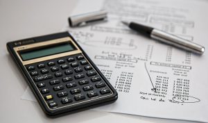 pen calculator and financial paperwork on desk