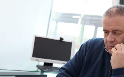 Man answering Spinal Injuries Association helpline in office