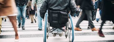 the back of a wheelchair centred in busy city environment