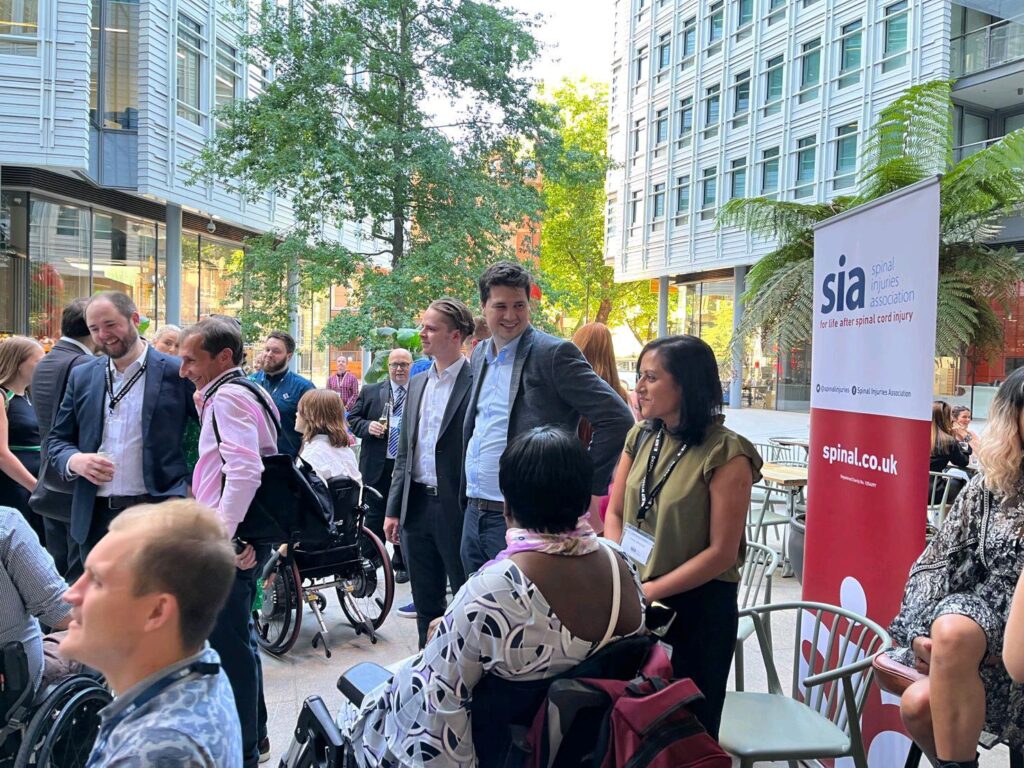 Group of people at corporate Fundraising event in city environment with SIA banner