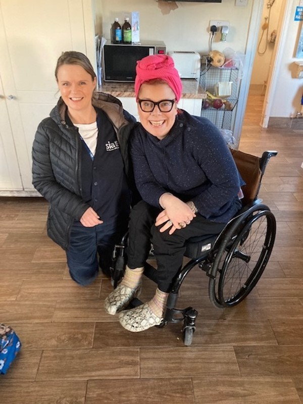 occupational therapist and client with a spinal cord injury smiling