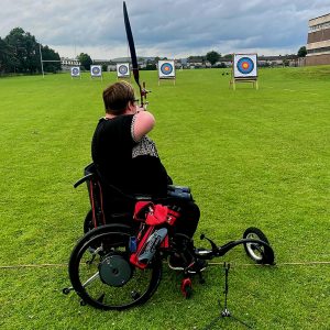 Tasha aiming her cross bow at a target.