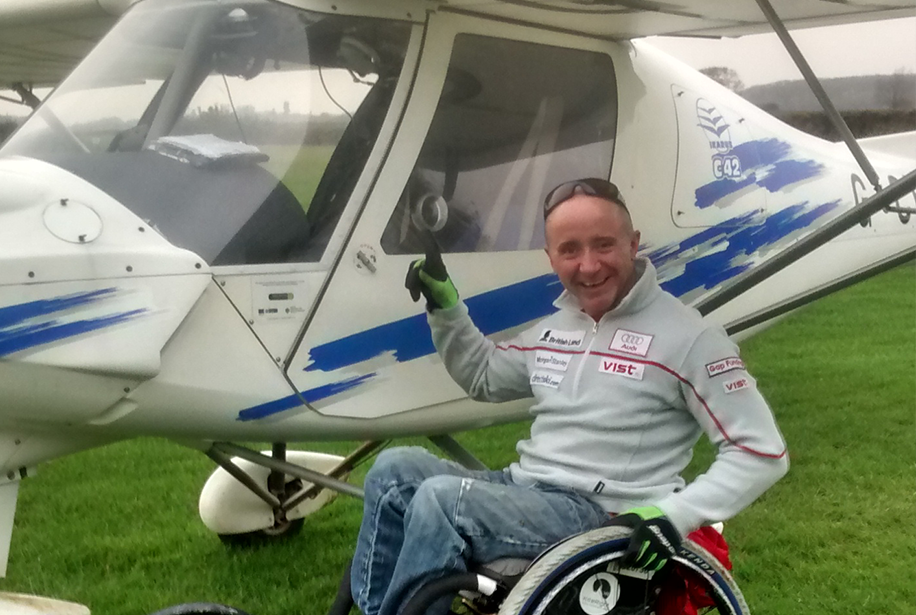 Male wheelchair user beside a light aircraft