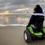 Back view of person using Omeo on a beach